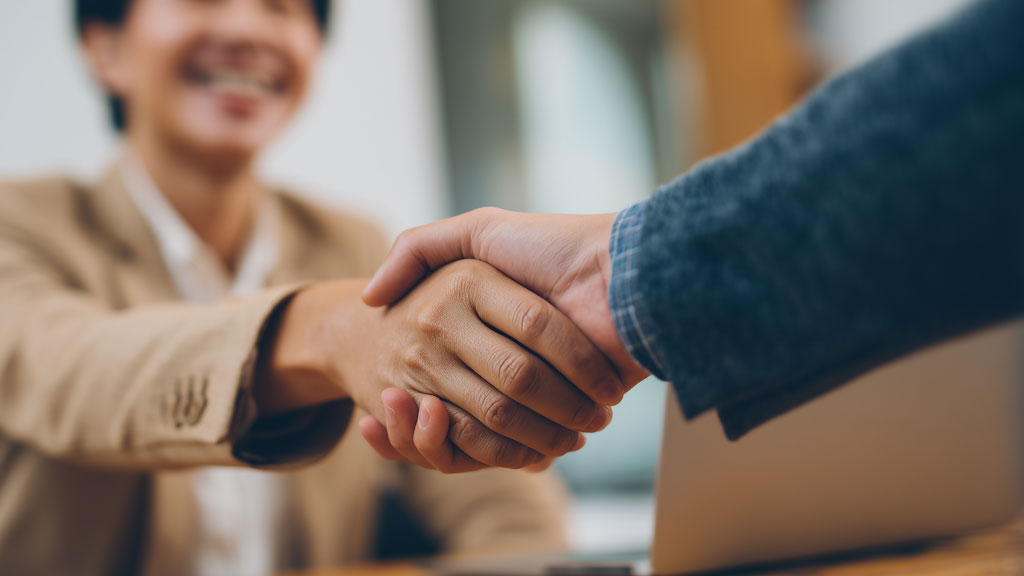 Propriétaire et gestionnaire immobilier consultant un écran dans une agence aux Sables d'Olonne